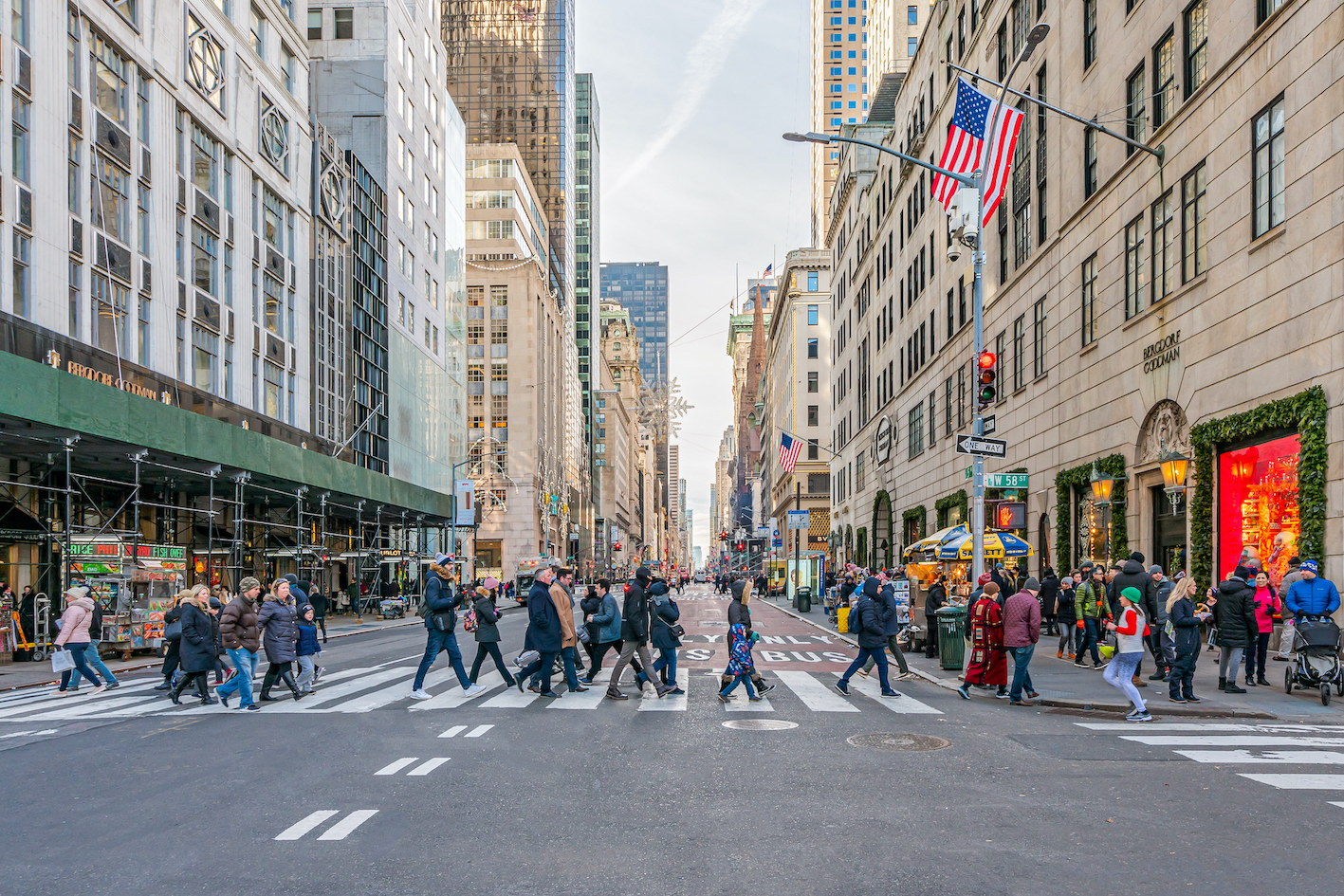 New York City, NY, USA - December, 2018 - Streets of Manhattan, people walking and crossing the street at West 58th with Fifth Avenue.